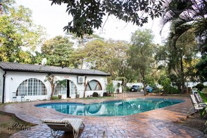Una piscina al aire libre, tumbonas