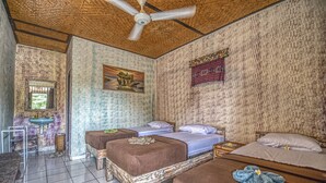Habitación con dos camas, ventilador de techo, lavamanos y espejo.