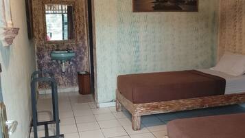 Ein Zimmer mit zwei Betten, einem Waschbecken, einem Fenster und einem Bild an der Wand.