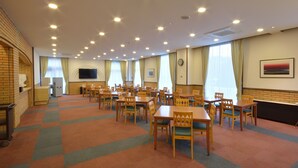 A conference room with multiple tables and chairs, a television, and a clock on the wall. - PRINCE HOTEL Second View MURORAN (Muroran)
