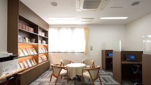 A library with bookshelves, a table with chairs, and individual workstations. - PRINCE HOTEL Second View MURORAN (Muroran)