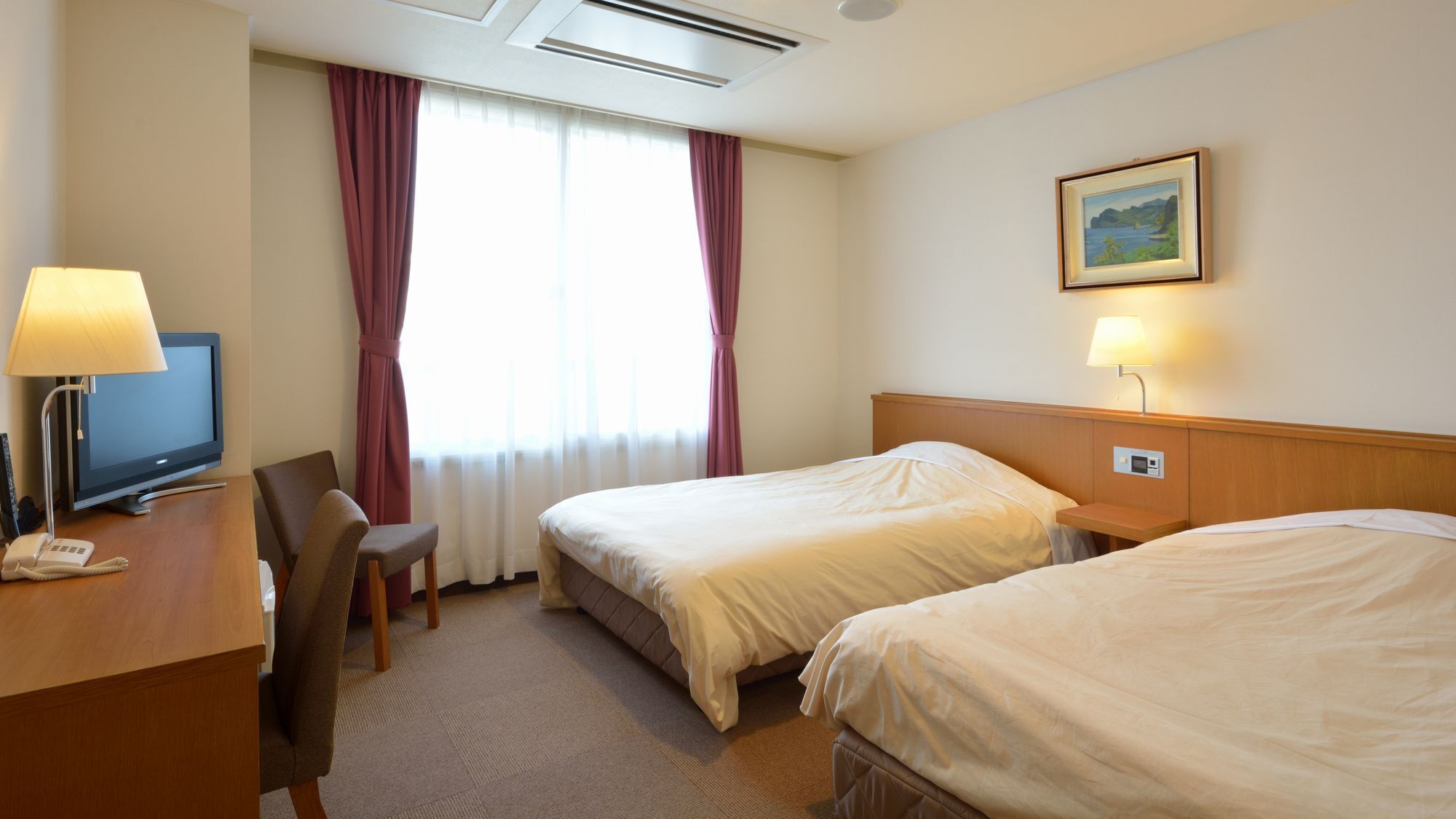 A hotel room with two beds, a desk with a television, a chair, a desk lamp, a painting on the wall, and a window with curtains.