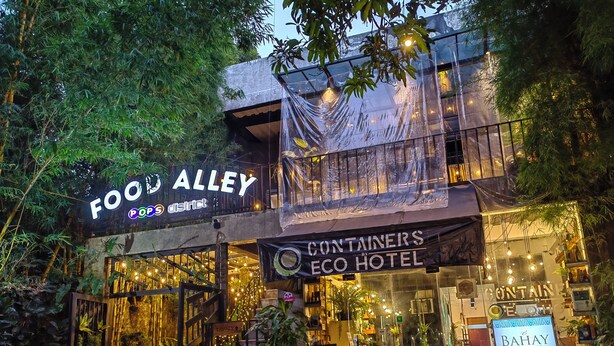 Un restaurant appelé « Food Alley », avec une enseigne indiquant « Bahay Kafe » et « Container’s Eco Hotel ».