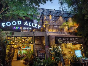 Ein Gebäude mit einem Schild, auf dem "FOOD ALLEY" und "Containers by Eco Hotel" steht.