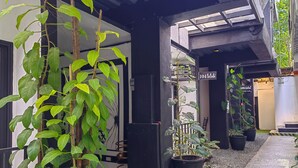 Un espace extérieur abrité, agrémenté de plantes en pot et d’un chemin.
