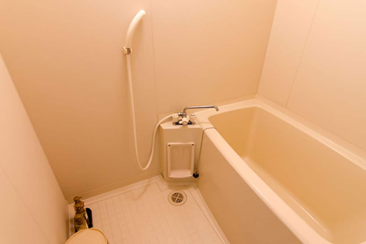 A small, clean bathroom with a bathtub, a shower, and a toilet.