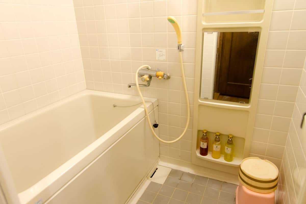 A bathroom with a bathtub, a shower, and a toilet.
