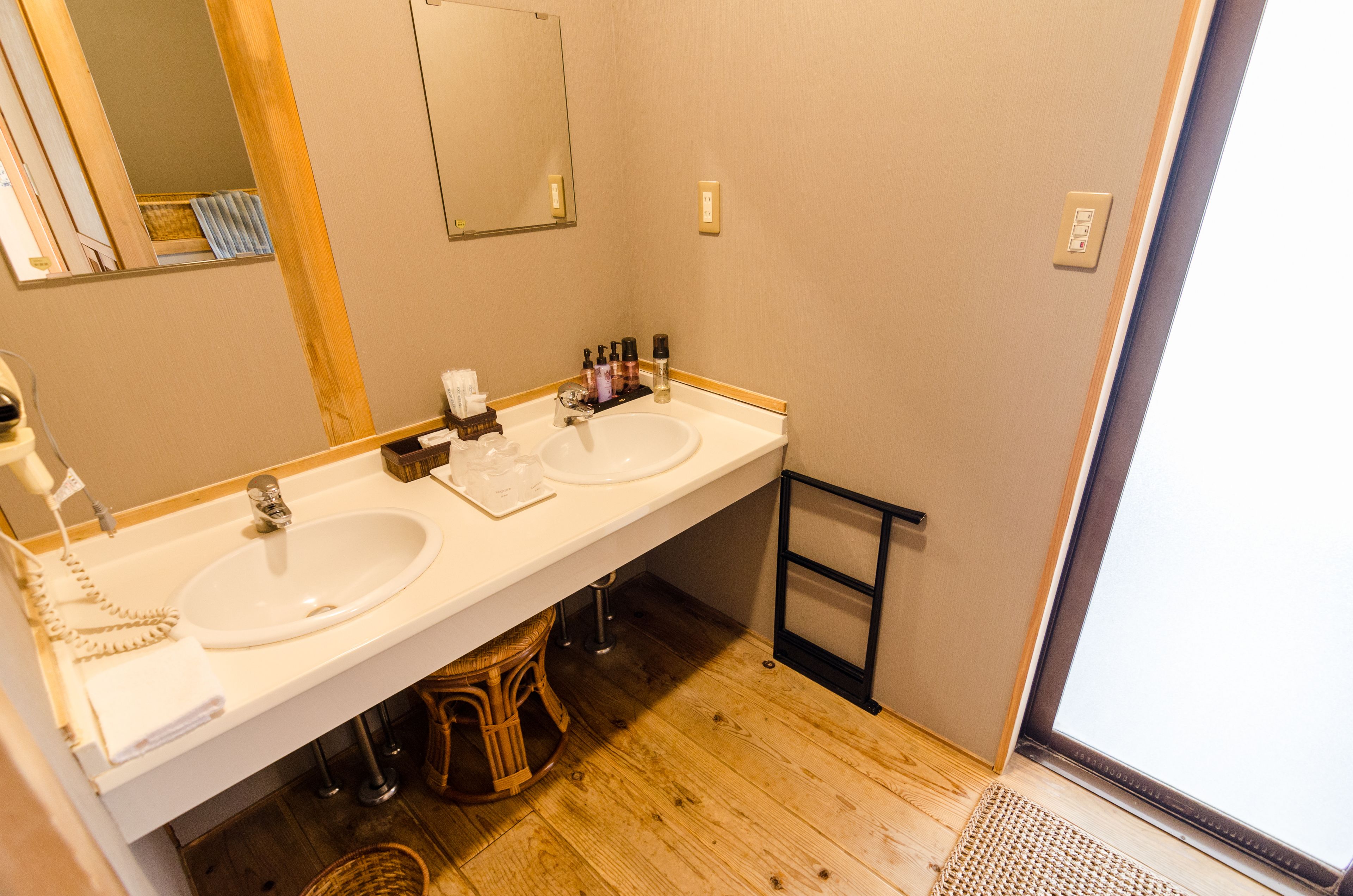 A bathroom with two sinks, a mirror, and a shower area.