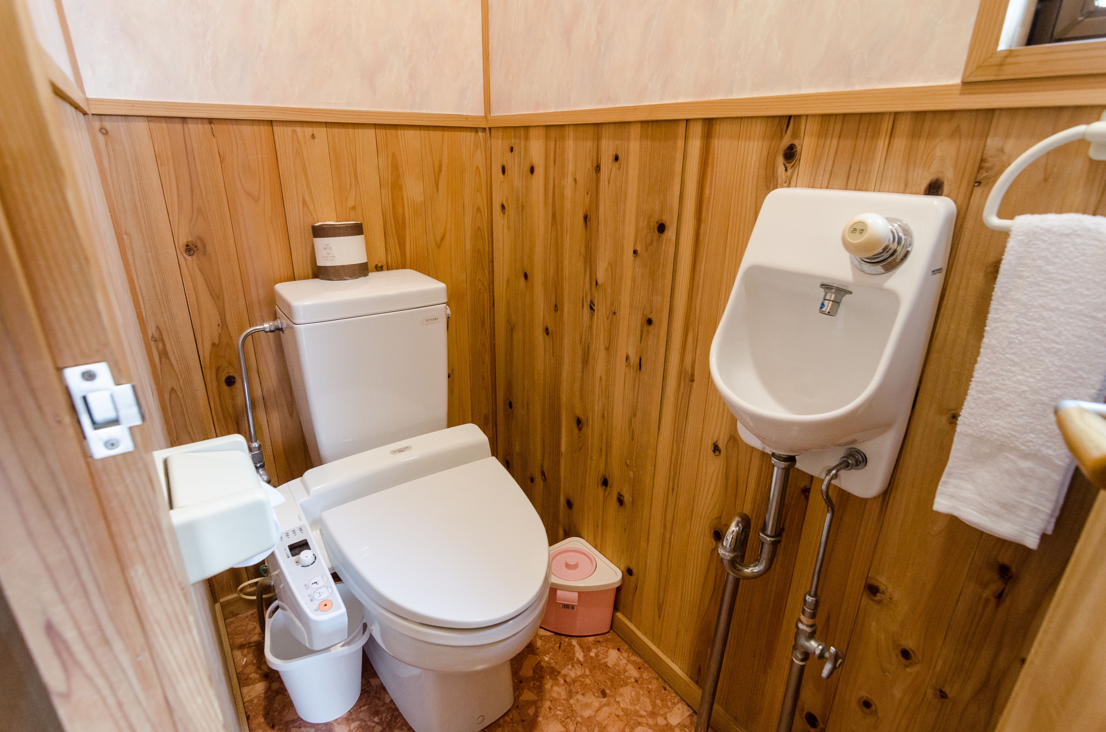 A compact bathroom with a toilet, bidet, and sink.
