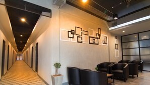 A modern hotel lobby with a checkered floor, black leather seating, and geometric wall art. - Sabai@Chiang Rai (Chiang Rai)