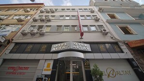 A hotel with multiple signs reading "OTEL ALTAY" and a red flag hanging from the building. - Otel Altay (Samsun)