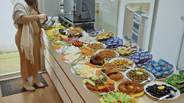 A buffet table with various food items and a coffee machine. - Otel Altay (Samsun)