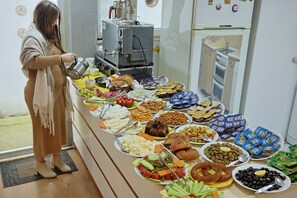 A buffet table with various food items and a coffee machine. - Otel Altay (Samsun)