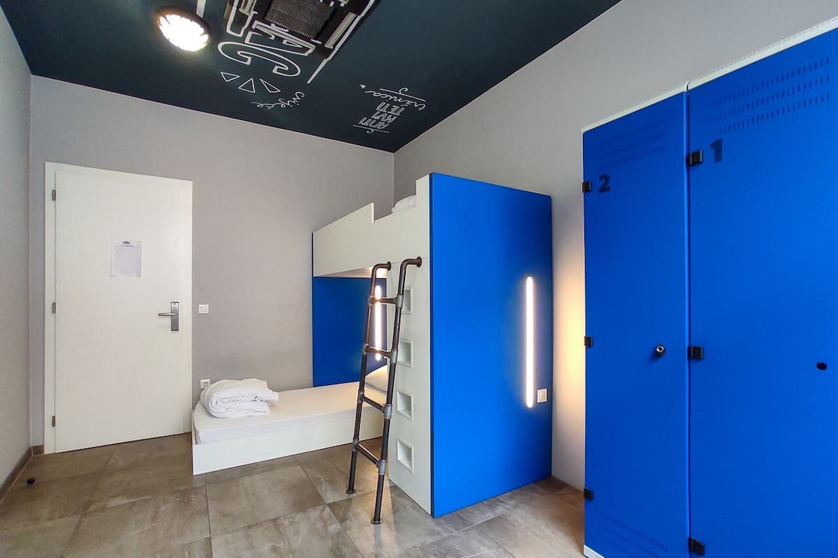 Ein modernes Badezimmer mit einem weißen Waschbecken, einem Spiegel und einem blauen Stauraum.