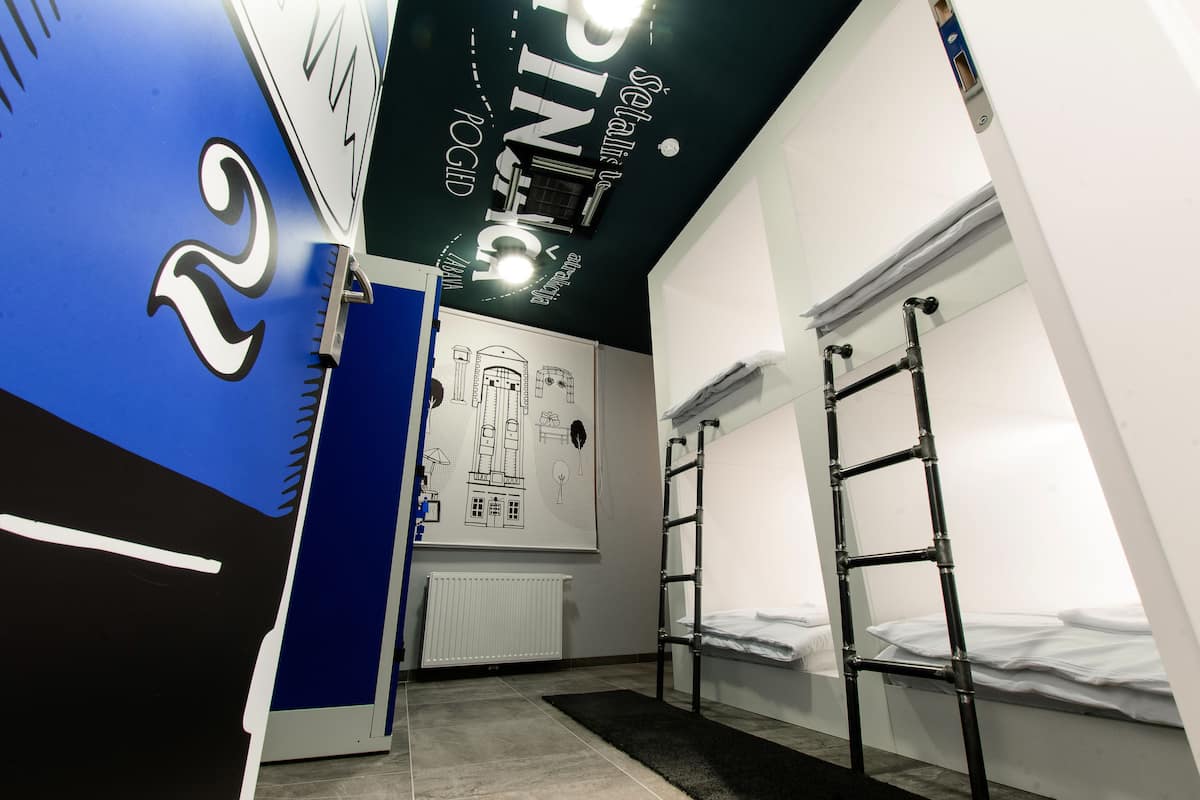 Ein Zimmer mit Etagenbetten, einem Heizkörper und einer Wand mit architektonischen Zeichnungen.