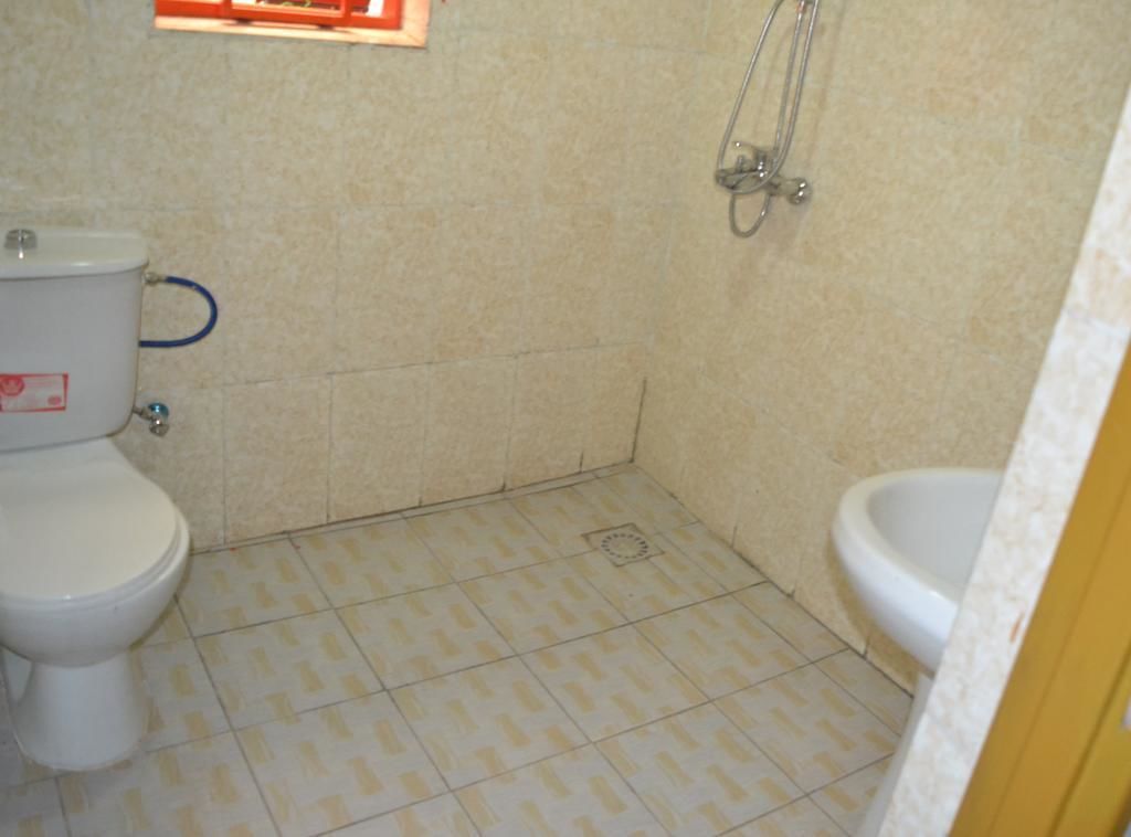 A small bathroom with a toilet, bidet, and shower.