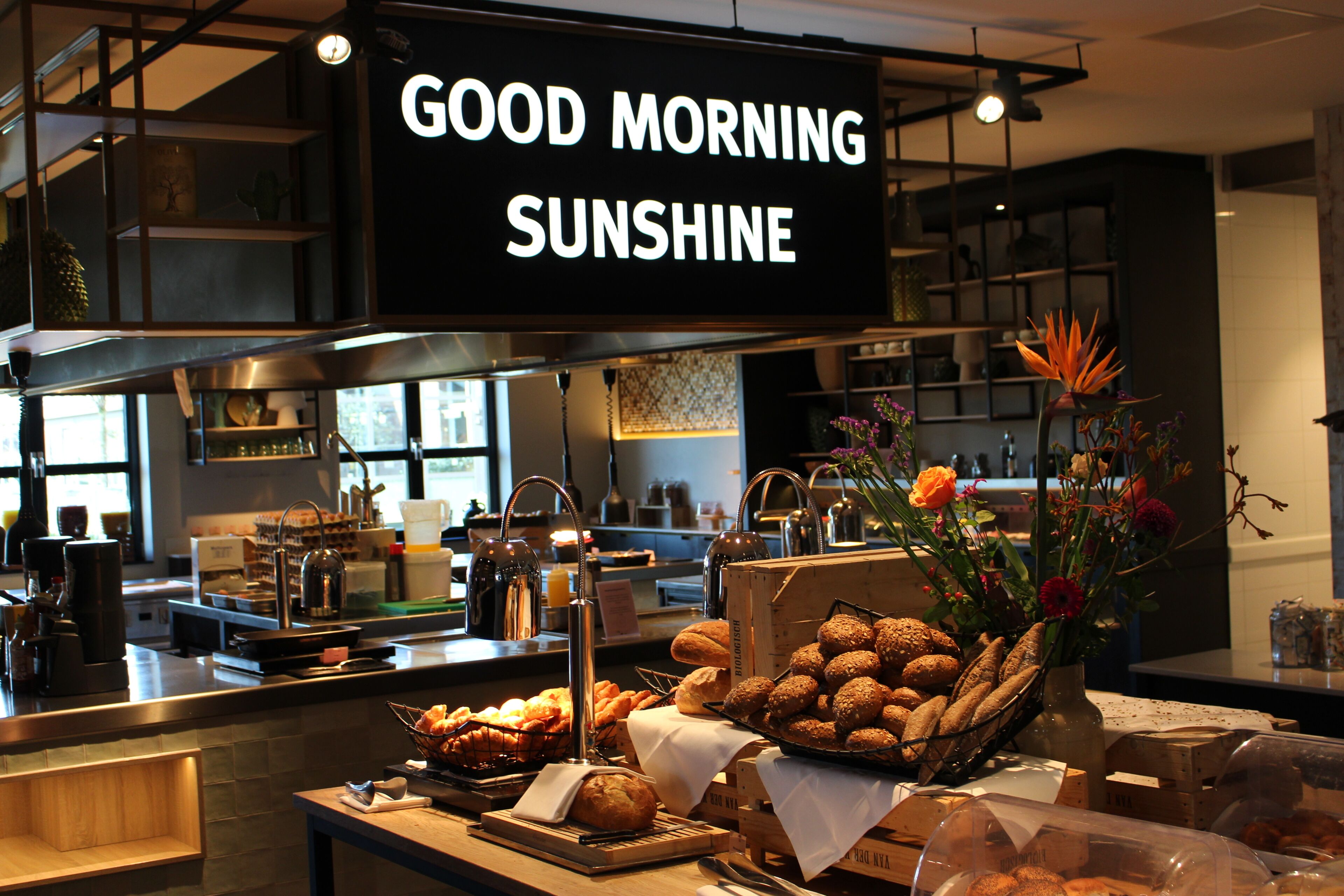 A breakfast buffet with various baked goods and a sign that reads 'GOOD MORNING SUNSHINE'.