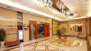 A spacious lobby with a polished marble floor, a grand chandelier, and a reception desk. - Badun International Apartment (Guangzhou)