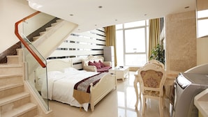 A bedroom with a bed, a chair, a washing machine, and a staircase. - Badun International Apartment (Guangzhou)