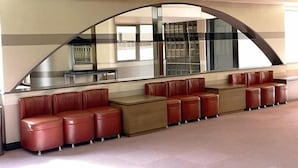A modern waiting area with leather seating and a large arched window. - Hotel Royal Oak Gotanda (Tokyo)