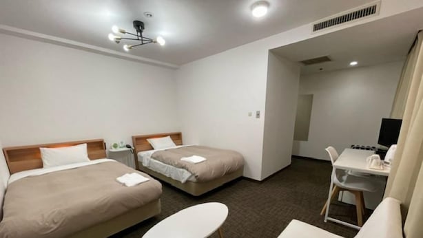 A hotel room with two beds, a small round table, a sofa, a desk with a computer, and a TV. - Hotel Royal Oak Gotanda (Tokyo)