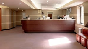 A reception area with a wooden reception desk, a clock, and a window on the right. - Hotel Royal Oak Gotanda (Tokyo)