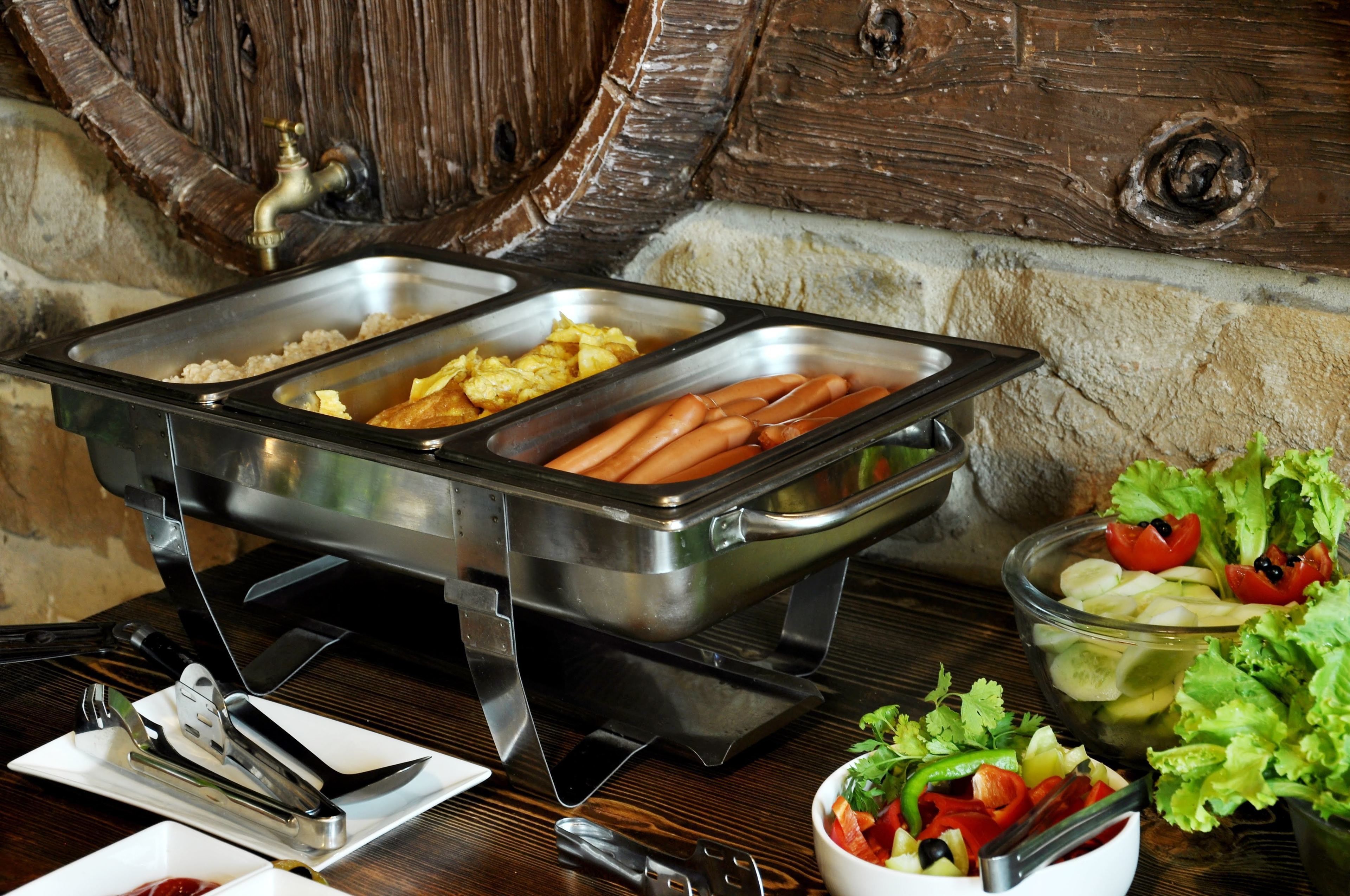 A buffet setup with various food items and utensils.