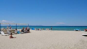 En la playa, camastros, sombrillas y bar en la playa