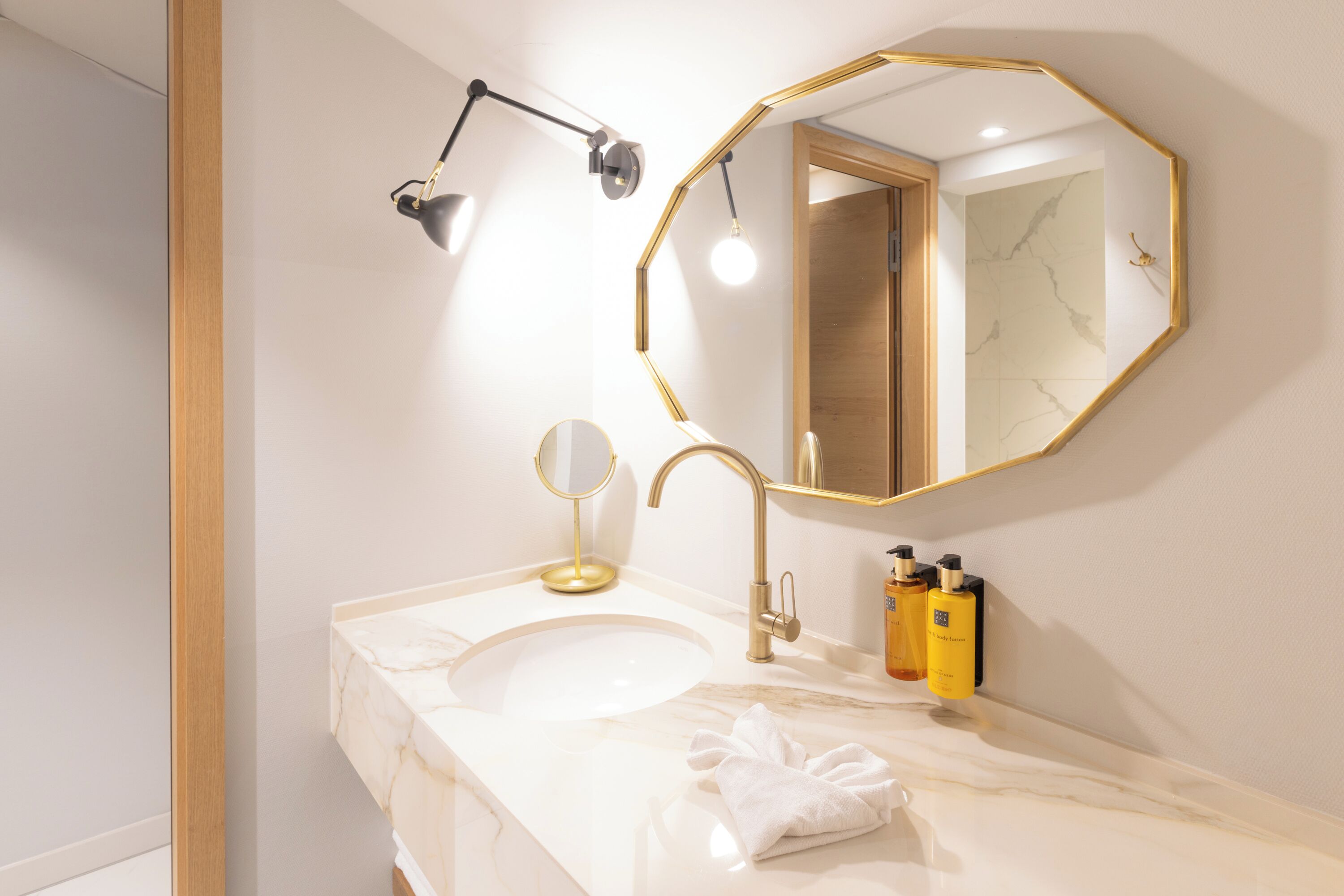 Un bagno con lavandino, specchio, asciugamano e articoli da toilette.