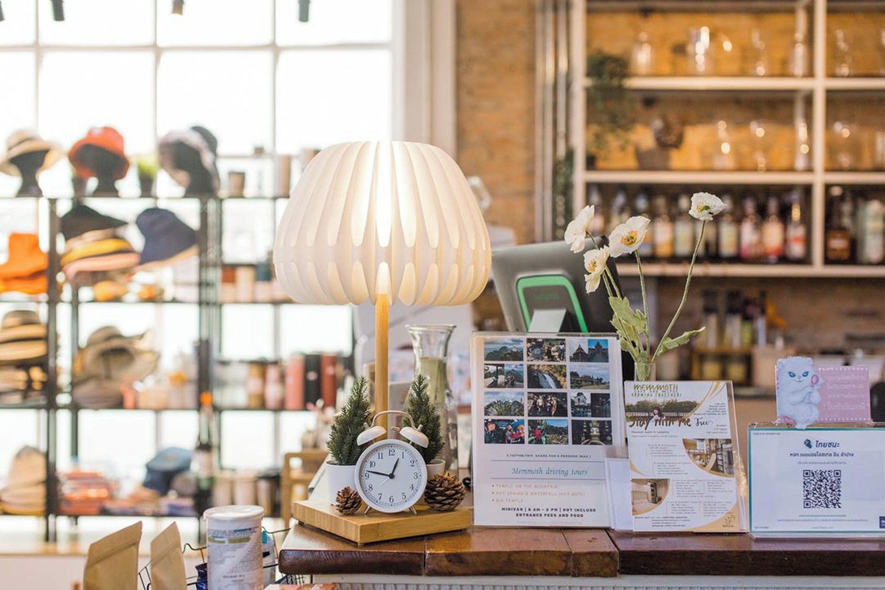 A counter with a clock, a lamp, brochures, and a QR code.