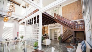 Un interior espacioso con techo alto, una escalera y una zona de estar.