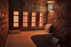 Un sauna avec des bancs en bois, des murs en pierre et un plafond incliné.