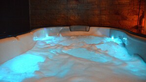 Un jacuzzi con una pared de ladrillo al fondo.
