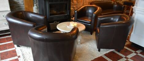 A cozy living room with leather sofas, a fireplace, and a checkered floor.