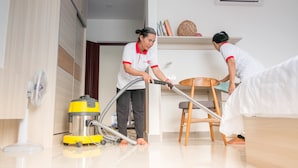 A room with a large wardrobe, a standing fan, a vacuum cleaner, and a bed. - Service One (Phnom Penh)