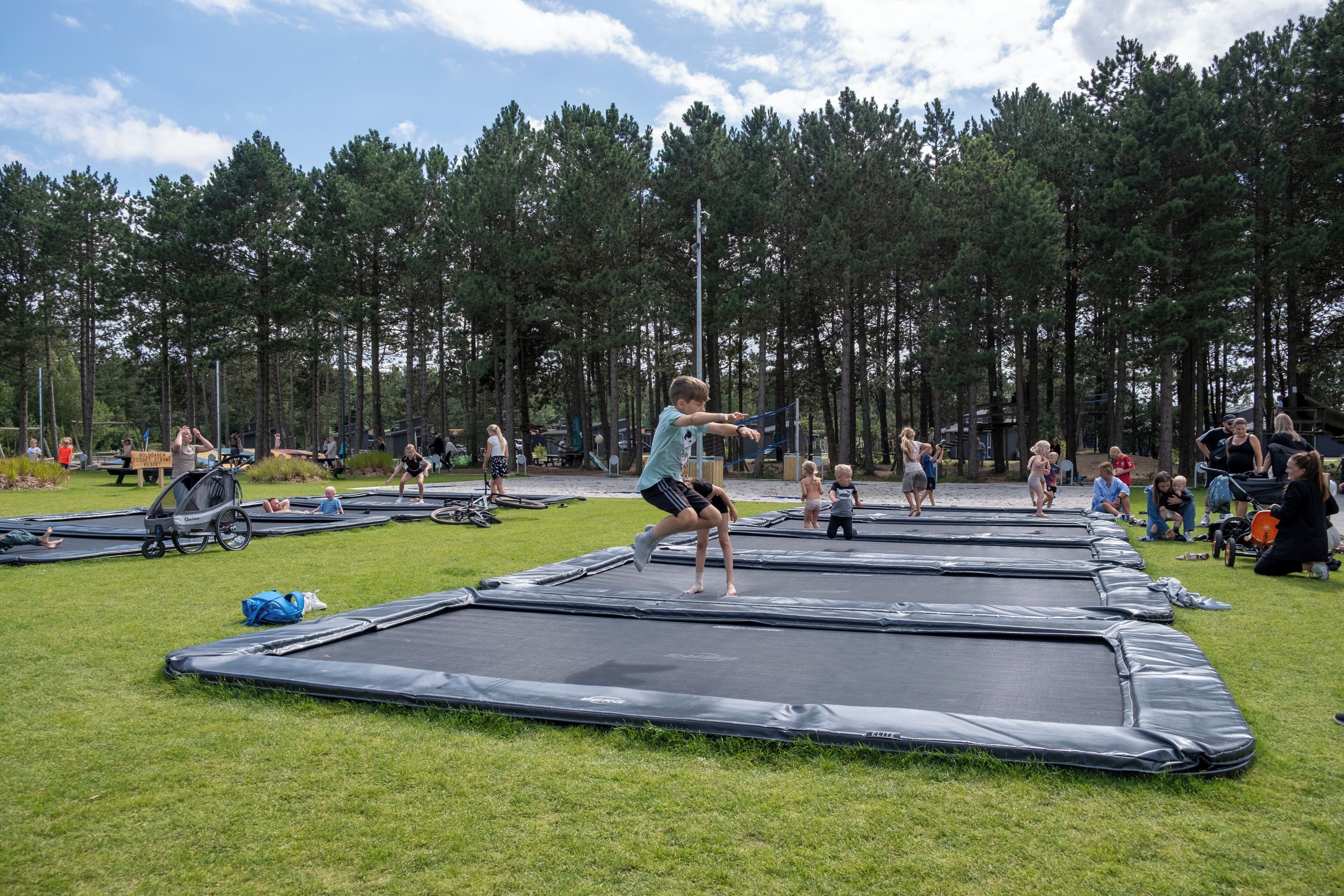 A trampoline park with multiple trampolines and people playing.