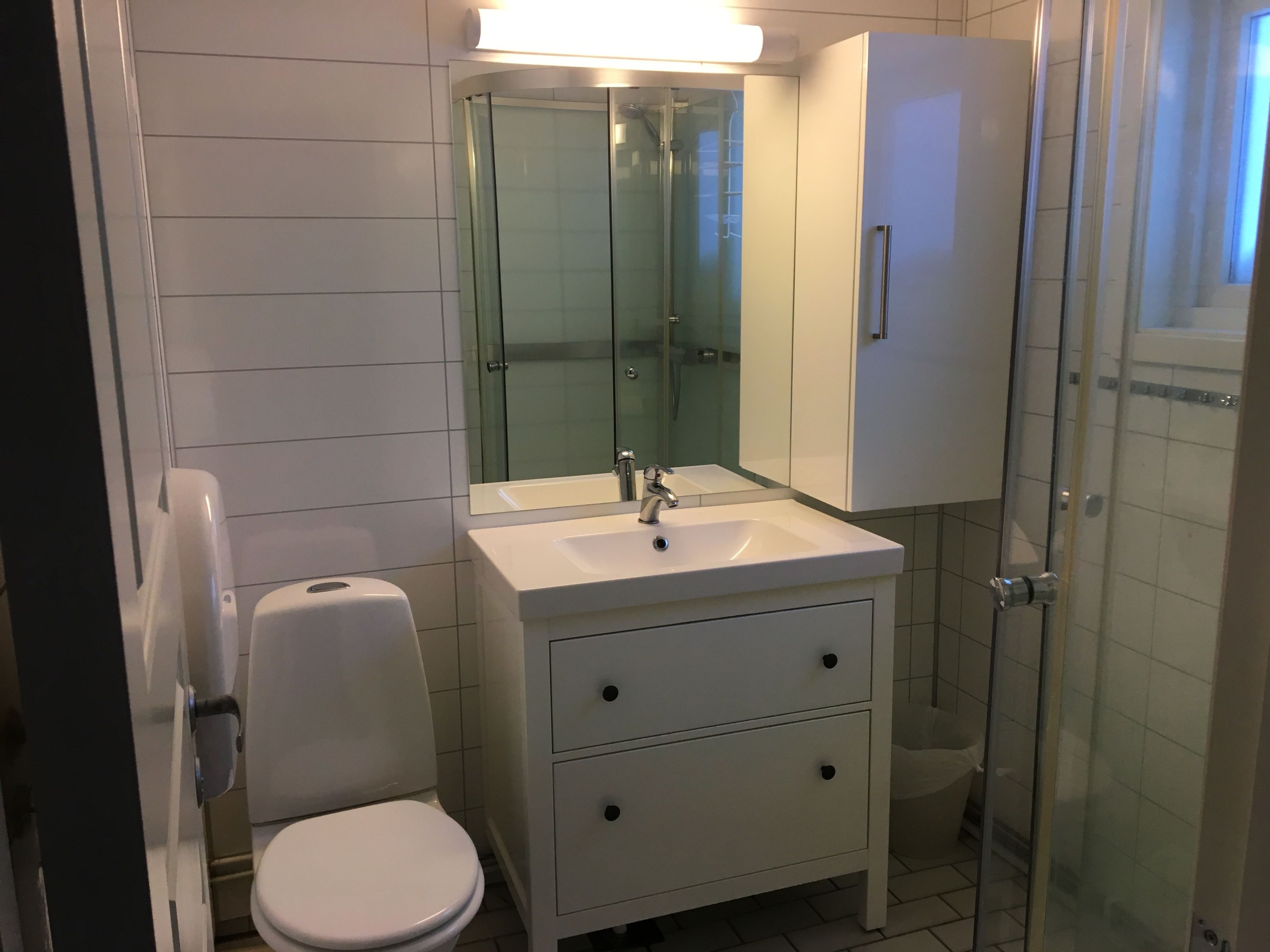Un baño moderno con inodoro, lavabo y cabina de ducha de vidrio.