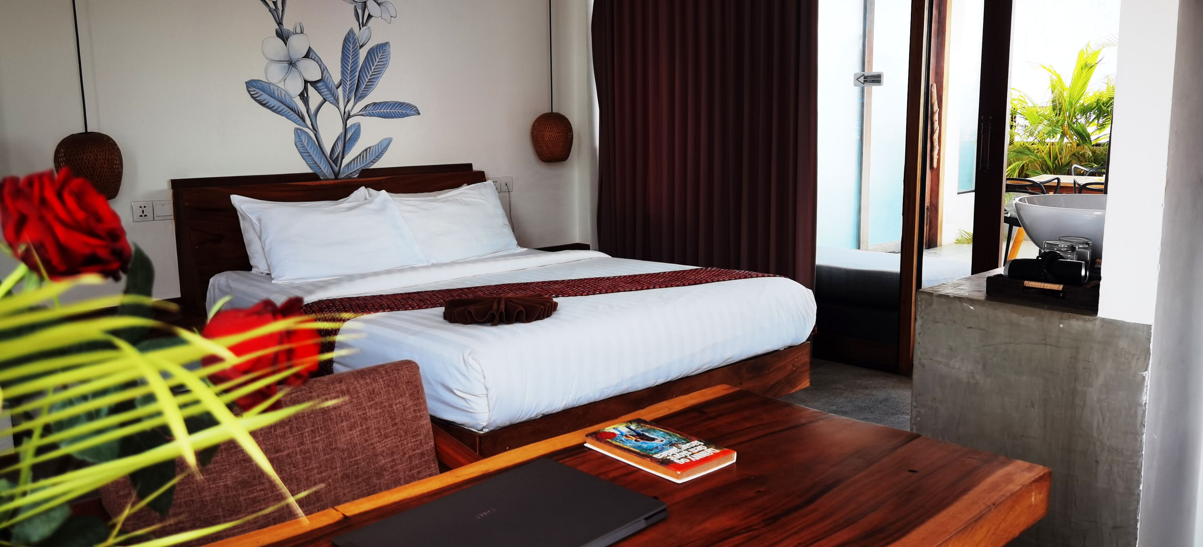 A modern hotel room with a wooden bed, a small wooden table, and a view of the outdoors.