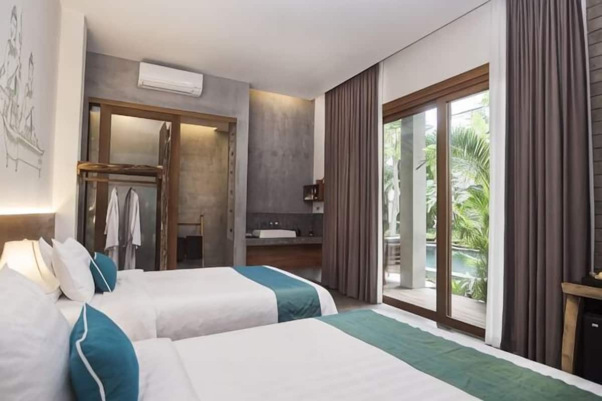 Une chambre d’hôtel avec deux lits, une salle de bain et un balcon offrant une vue.