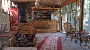 A rustic bar area with wicker furniture and a Coca-Cola advertisement.
