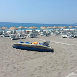 På stranden, solstolar och parasoller