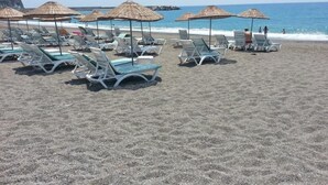 A beach with rows of sun loungers and thatched umbrellas. - Grand Akca Hotel (Gazipasa)