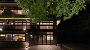 A modern building with a wooden deck, large windows, and a tree in front. - Hotel Hakone Terrace (Hakone)