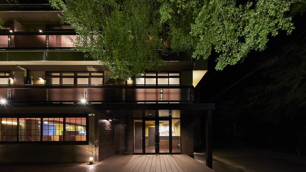 A modern building with a wooden deck, large windows, and a tree in front. - Hotel Hakone Terrace (Hakone)