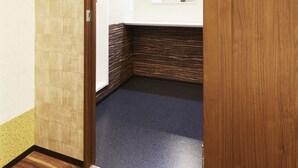 A hallway with a wooden door, a tiled wall, and a carpeted floor. - Hotel Hakone Terrace (Hakone)