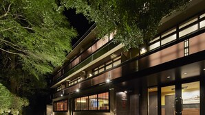 A modern building with a glass facade, multiple floors, and a well-lit entrance. - Hotel Hakone Terrace (Hakone)
