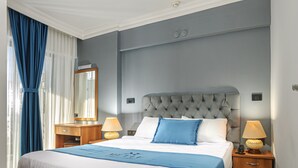 A modern bedroom with a large bed, two bedside tables, a mirror, and a window with curtains. - Mutlu Apart Otel (Didim)