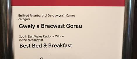 A framed award certificate for The Greyhound Inn & Hotel, stating it won the Best Bed & Breakfast in the category of South East Wales Regional Winner in 2018.