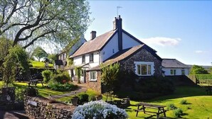 A traditional stone house with a garden, a picnic table, and a stone wall. - The Greyhound Inn & Hotel (Usk)