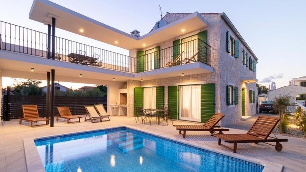A two-story house with a swimming pool, outdoor seating, and a balcony. - Apartments Corte (Privlaka)